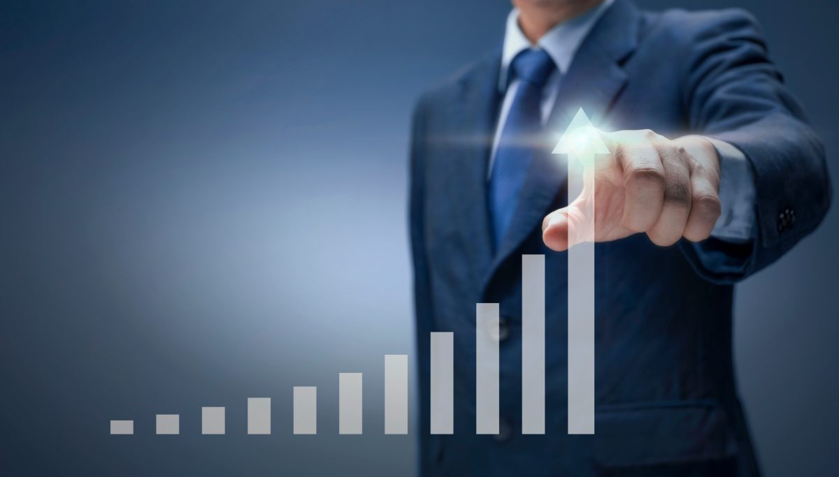 Businessman pointing at an upward graph