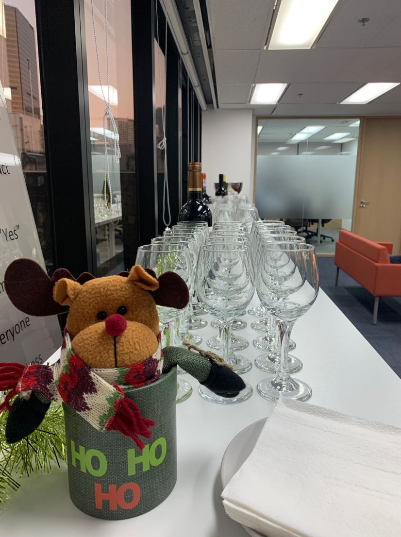 Image of a raindeer toy in a box on a table with neatly arranged wine glasses