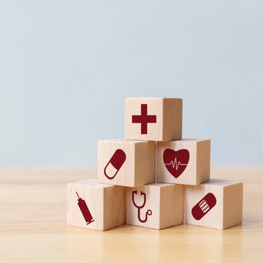 Six wood cubes, each displaying a healthcare icon