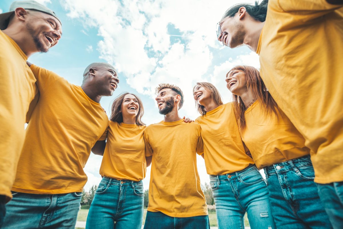 Group of young people in yellow t-shirts hugging