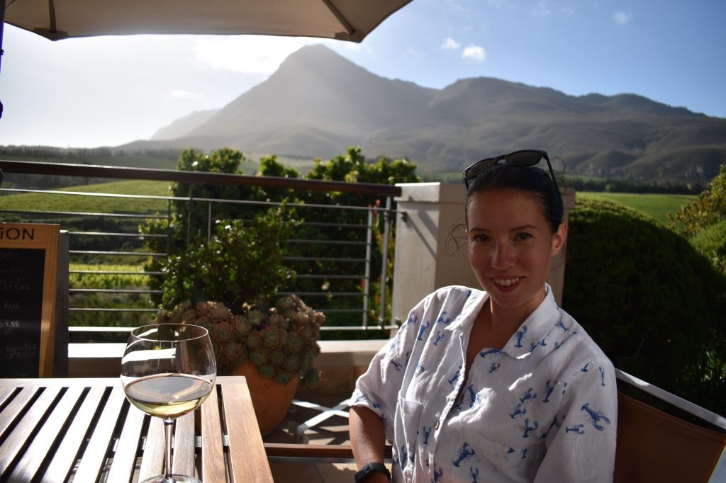 Photo of Rosie Gibson on a trip to a vineyard with a mountain in the background.