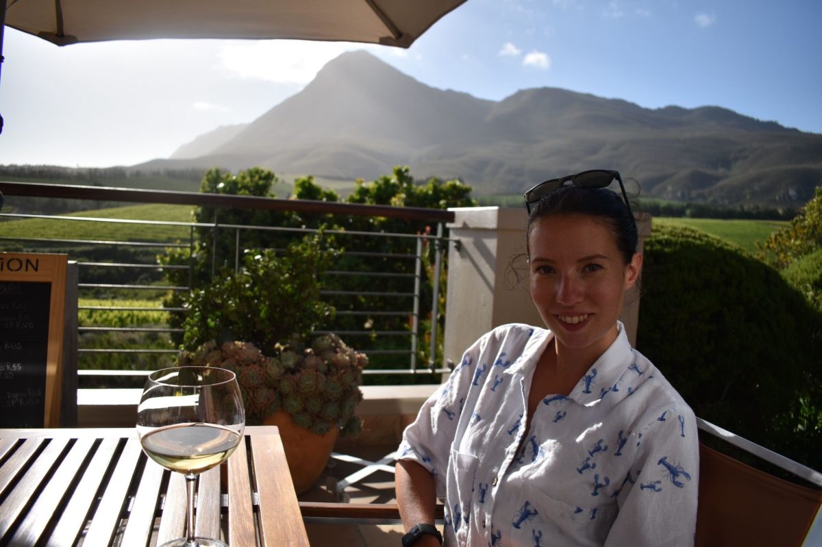 Photo of Rosie Gibson on a trip to a vineyard with a mountain in the background.