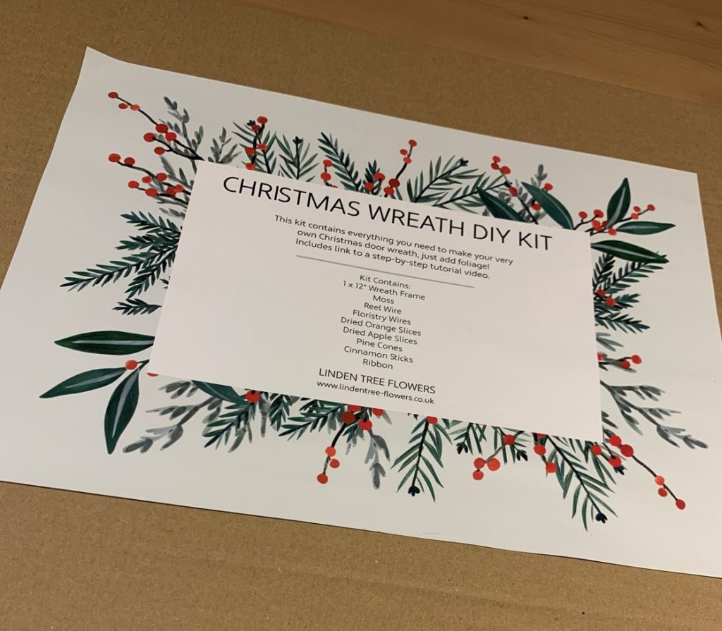 Image of a card showing a card with the title Christmas Wreath DIY Kit, showing basic introduction and what the kit contains and the company name, linden tree flowers.