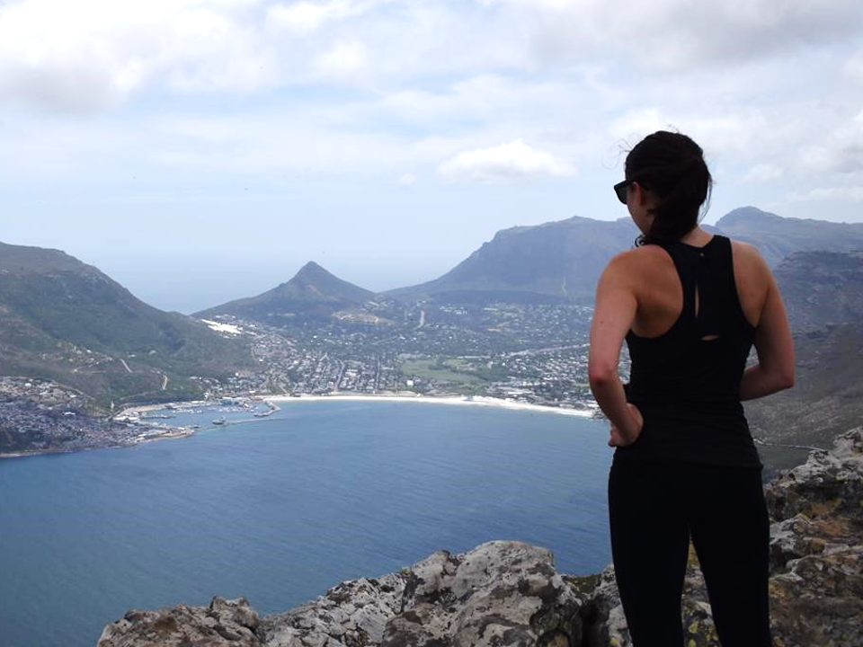 Photo of Rosie Gibson on a mountain looking at a beach in South Africa.