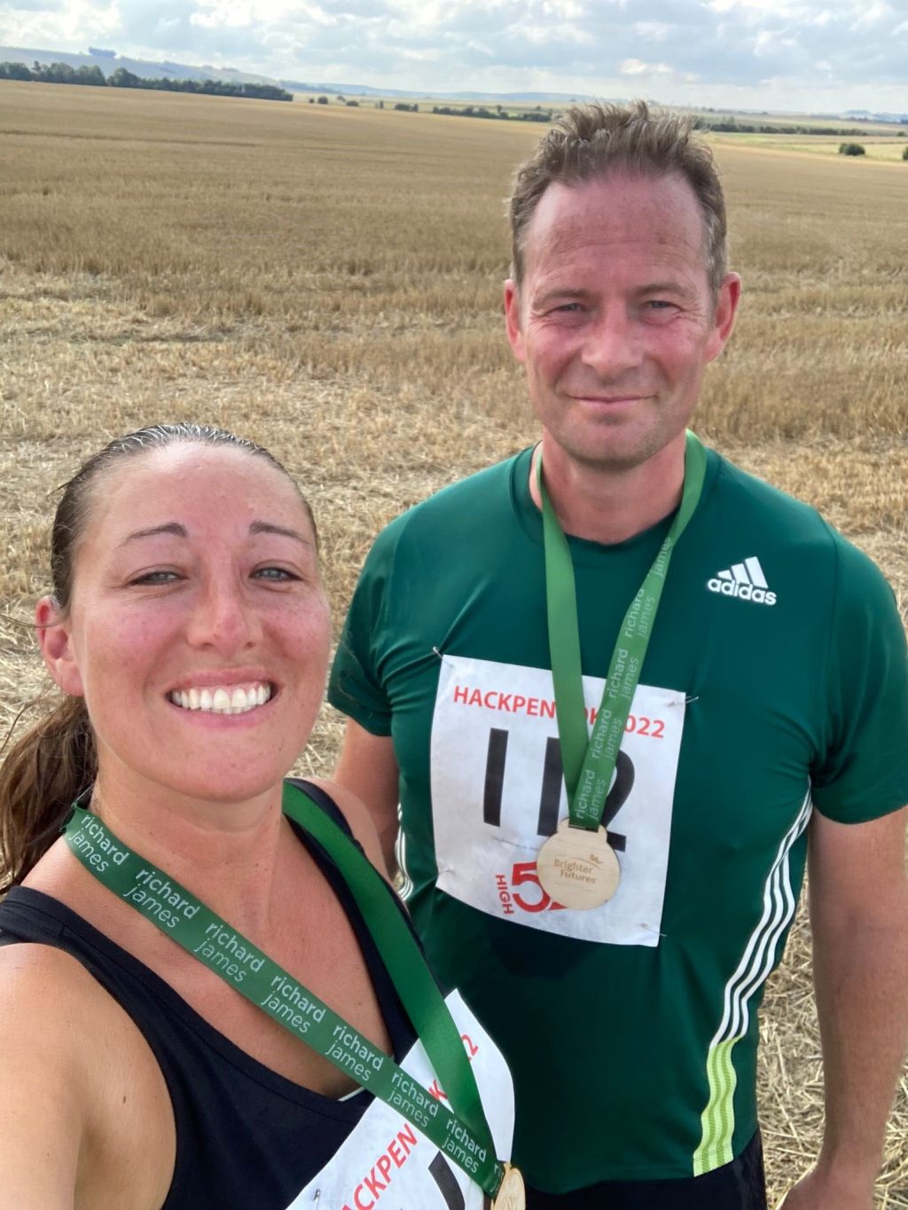 Photo of Kate Huggins and her partner after the brighter futures marathon with medals.