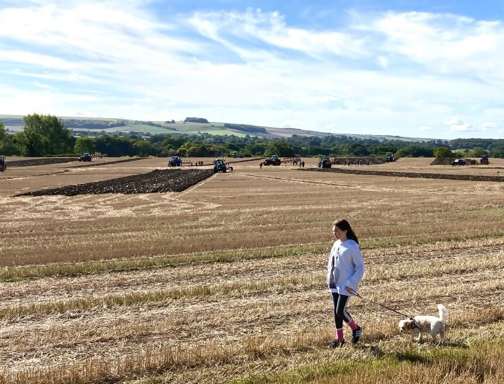 Photo of Kate Huggins walking her dog on the fields.
